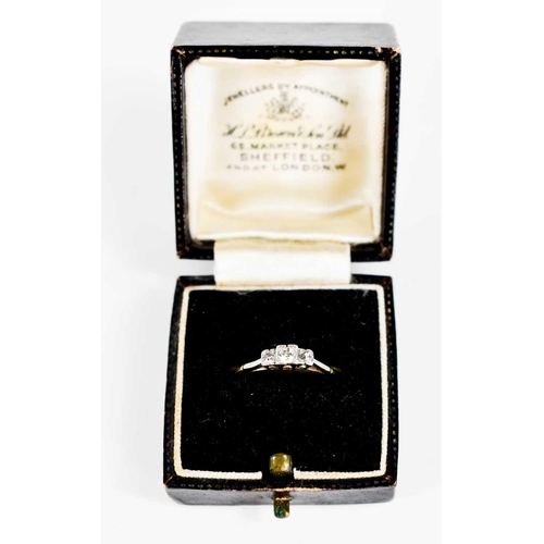 117 - An Art Deco 18ct gold, platinum and diamond three stone ring, the central illusion set stone of appr... 