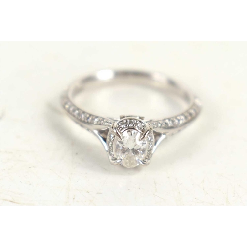 149 - An 18ct white gold, diamond oval solitaire ring, with diamonds to the shoulders, marked 750, 0.56cts... 