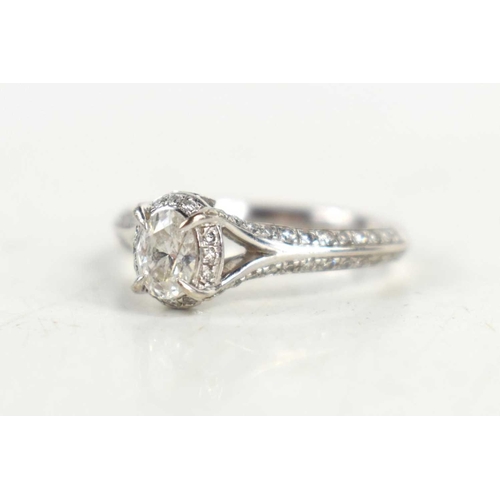 149 - An 18ct white gold, diamond oval solitaire ring, with diamonds to the shoulders, marked 750, 0.56cts... 