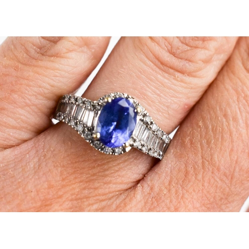 150 - An 18ct white gold ring set with tanzanite and baguette cut diamonds, oval cut stone 1.25ct, 3.8g.