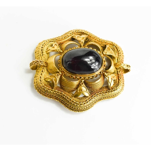 158 - A 19th century gold and cabochon garnet brooch, the central oval garnet centring a decorative filigr... 