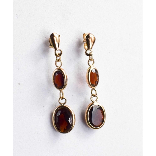 194 - A pair of 9ct gold and garnet drop earrings, each set with two graduated oval cut garnets, with 9ct ... 