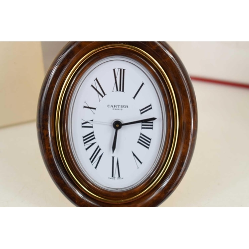 272 - A Must de Cartier Pendulette travel alarm clock, having a signed oval white enamel dial, with deep t... 