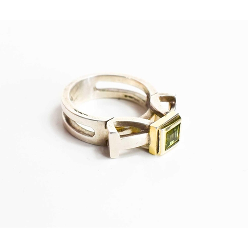 29 - A silver and parcel gilt ring, set with an emerald cut peridot, by jewellery designer Christopher An... 