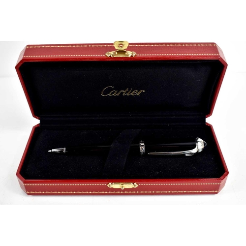 302 - A Cartier ballpoint pen, black composite body and cap, palladium-finish details, blue resin cabochon... 