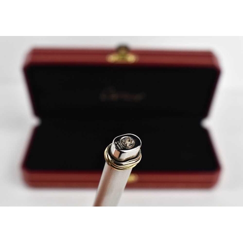 303 - A Cartier ball point pen, with rose, yellow and white gold band to the pen lid, no.475802, in the or... 