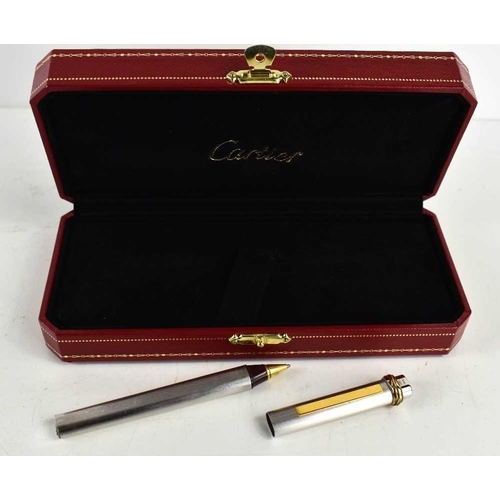 303 - A Cartier ball point pen, with rose, yellow and white gold band to the pen lid, no.475802, in the or... 