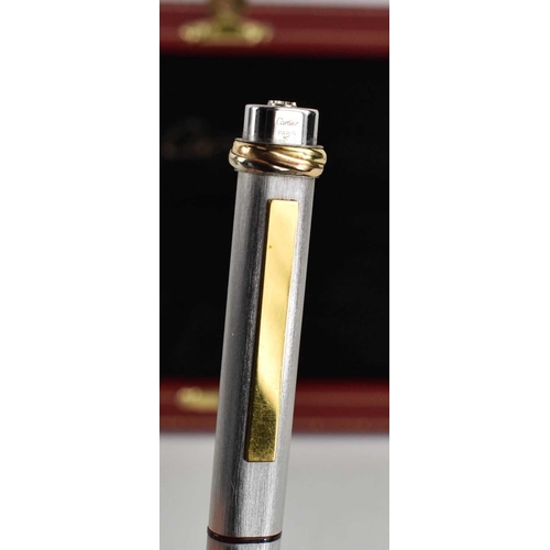 303 - A Cartier ball point pen, with rose, yellow and white gold band to the pen lid, no.475802, in the or... 