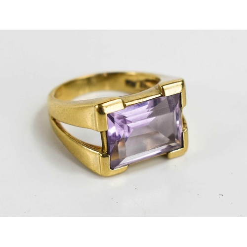 53 - A 9ct gold and amethyst set dress ring, the emerald cut amethyst set in V-cut shoulders, size K, 5.4... 