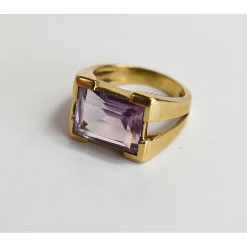 53 - A 9ct gold and amethyst set dress ring, the emerald cut amethyst set in V-cut shoulders, size K, 5.4... 