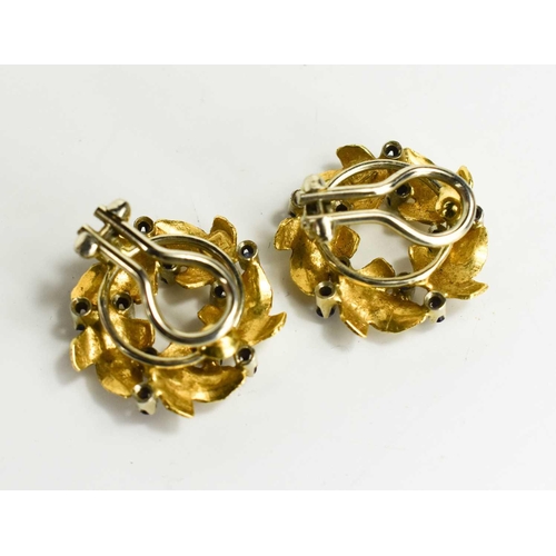55 - A pair of 18ct gold and sapphire clip on earrings, in the form of a wreath of leaves with brilliant ... 