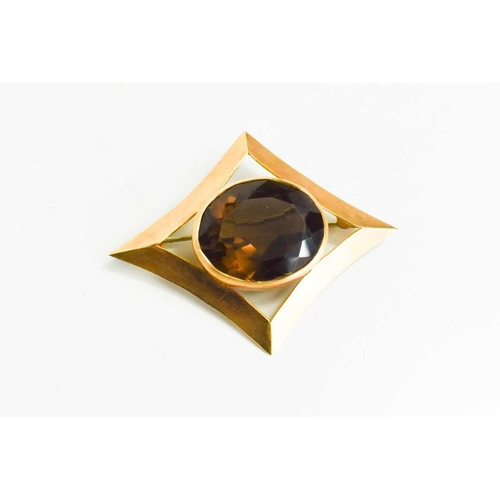 68 - A 14ct gold and smokey quartz brooch, the diamond form setting with oval quartz, 5 by 3.5cm, 10.7g.