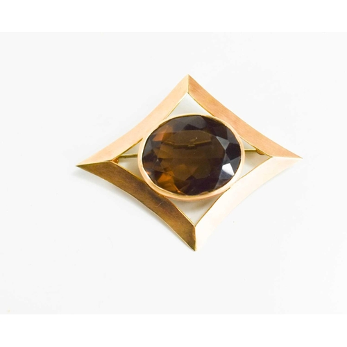 68 - A 14ct gold and smokey quartz brooch, the diamond form setting with oval quartz, 5 by 3.5cm, 10.7g.