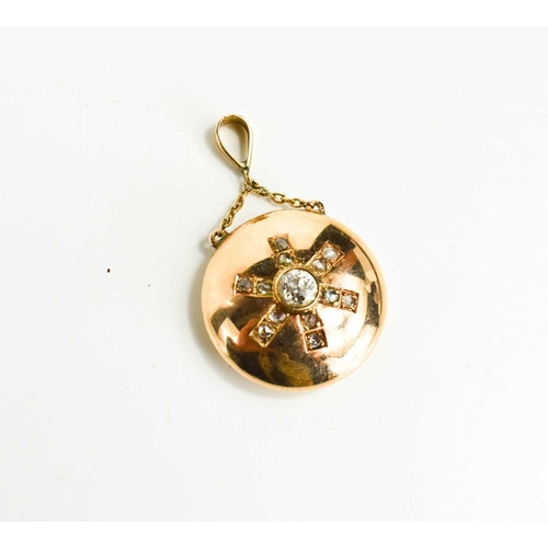 70 - A rose gold and diamond pendant, with hoop and chain to the top, and a starburst to the roundel, the... 