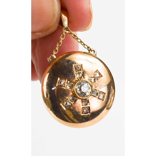 70 - A rose gold and diamond pendant, with hoop and chain to the top, and a starburst to the roundel, the... 