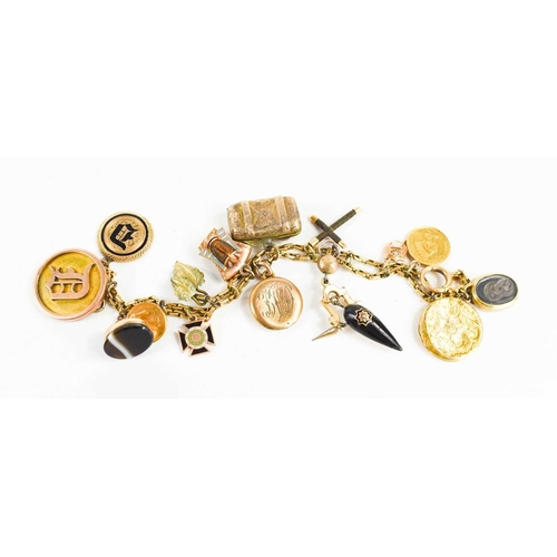 73 - A gold charm bracelet, with fifteen charms including enamelled pharoah head, mourning locket, agate ... 