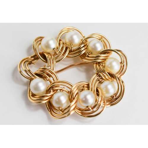 75 - A gold and pearl brooch, in a wreath style, set with eight pearls (one missing), unmarked but testin... 