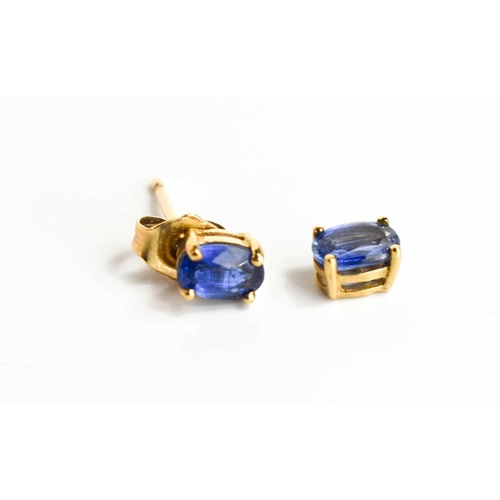 82 - A pair of 9ct gold and deep cornflower blue ear-studs, each oval stone of approximately 3.3 by 1.5mm... 