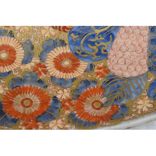 298 - A large 19th century Japanese Imari charger, decorated with patterns of fans and panels of flowers, ... 