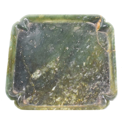 333 - An antique Chinese spinach jade dish, with recessed corners, 12.5cm by 11.5cm.