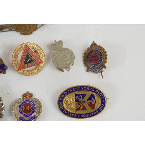 48 - A group of badges and brooches to include a Essex Regiment sweetheart brooch, Green Howards (Alexand... 