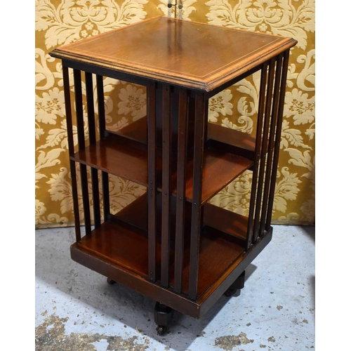 516 - An Edwardian mahogany revolving bookcase, the top with satin wood inlaid border.