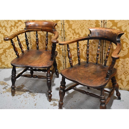 520 - Two elm Smokers bow chairs with swept scroll crest rails.