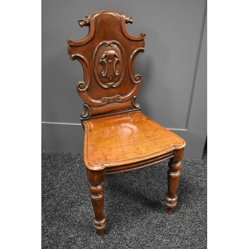 521 - A Victorian carved hall chair with scrolling shield back, 44 by 40 by 89cm high, seat height 44cm.