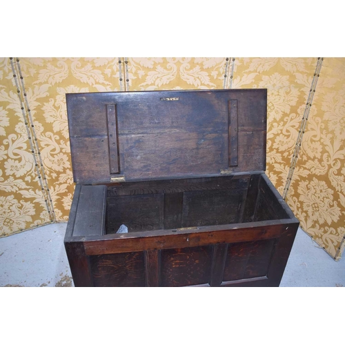 538 - An 18th century oak coffer with three panel front, the interior having a candle box, raised on stile... 