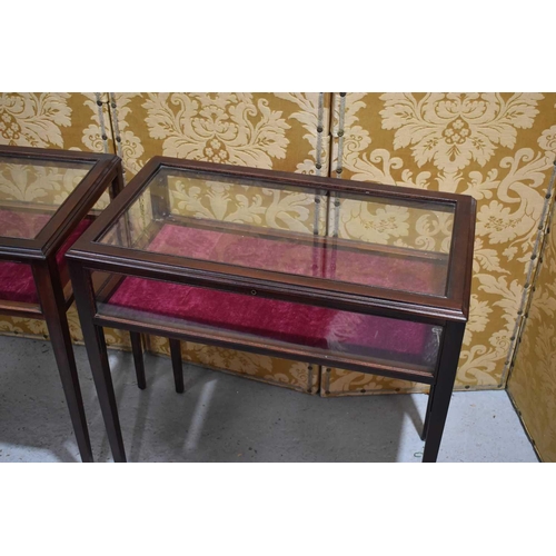 546 - A pair of mahogany vitrines or display tables, having hinged, lockable lids, burgundy velvet interio... 