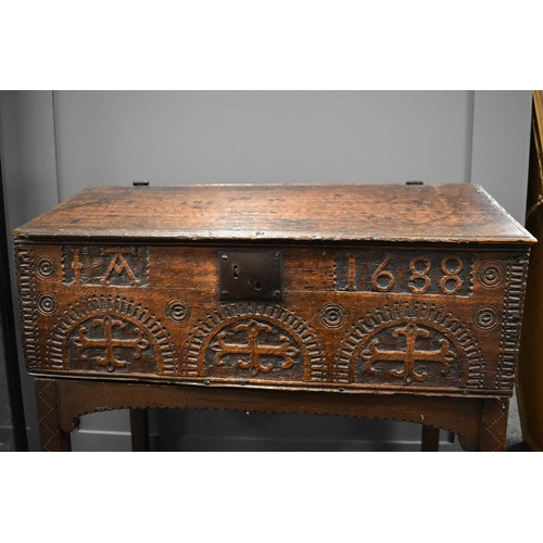 555 - A 17th century oak bible box on stand, the plank lid opens to reveal three small interior drawers, t... 