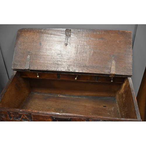 555 - A 17th century oak bible box on stand, the plank lid opens to reveal three small interior drawers, t... 