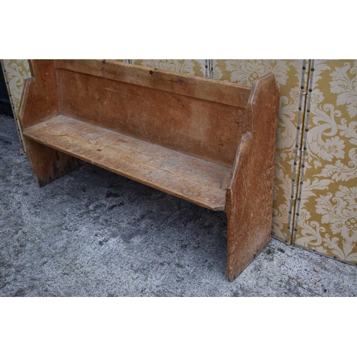 556 - A 19th century pine church pew, 152cm wide by 92cm high.