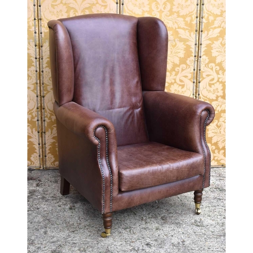 558 - A pair of brown leather wingback armchairs with studded detailing,made bespoke by IPEC, 113cm high b... 