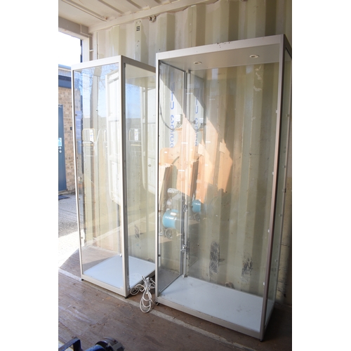 560 - Two modern glass display cabinets, with halogen light fittings and glass shelves.