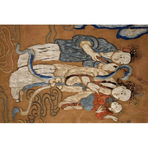 492 - A Chinese scroll with silk embroidered panel depicting two women holding a baby, with gentleman gest... 