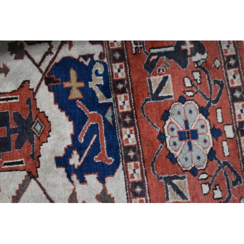 457 - A large rug, possibly Afghan, the cream central ground decorated with repeated geometric motif, link... 