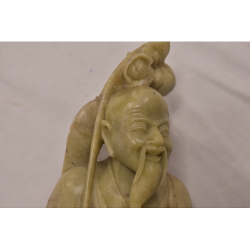 328 - A Chinese soapstone carved figurine of a fisherman, on a naturalistic rocky base 40cm high, together... 