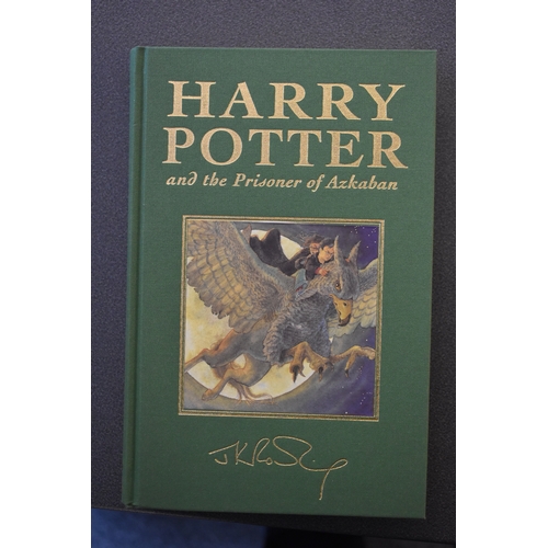 371 - A set of Harry Potter Deluxe edition books, the first five volumes bound in coloured fabric and enca... 