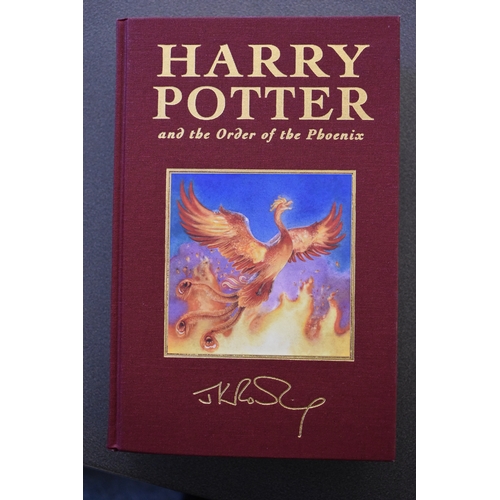 371 - A set of Harry Potter Deluxe edition books, the first five volumes bound in coloured fabric and enca... 