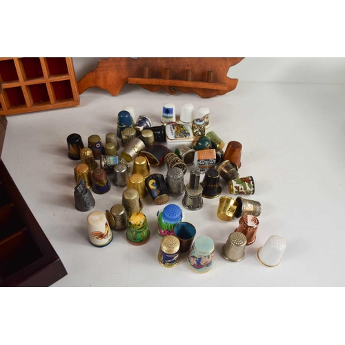 130 - A collection of porcelain and other various thimbles including places and location examples, and eig... 