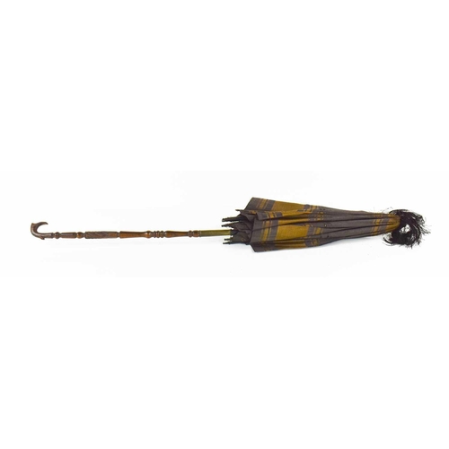 290 - A 19th century childs parasol, the decoratively carved handle in lignum vitae, with silk shade and b... 