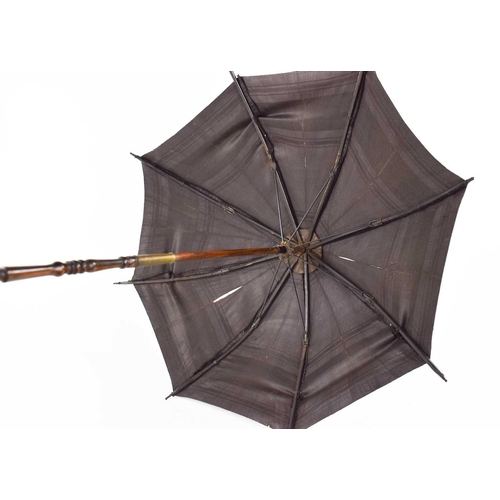 290 - A 19th century childs parasol, the decoratively carved handle in lignum vitae, with silk shade and b... 