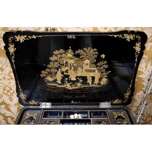 312 - A 19th century Chinoiserie black lacquered sewing table, decorated all over with figural scenes, and... 