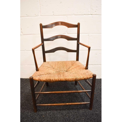 474 - A 19th century elm regional chair, with shaped ladder back, rush seat, and right angle arms, the leg... 