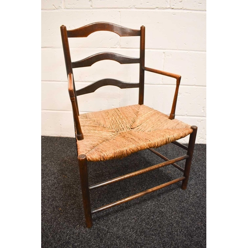 474 - A 19th century elm regional chair, with shaped ladder back, rush seat, and right angle arms, the leg... 