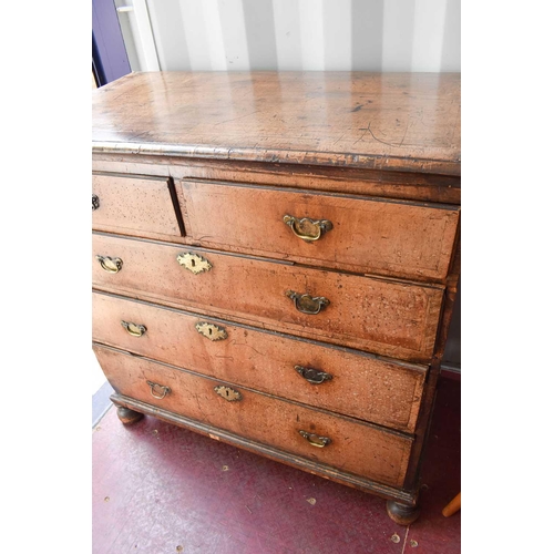 486 - An 18th century walnut chest of two over three drawers, with swan neck handles and brass lock plates... 