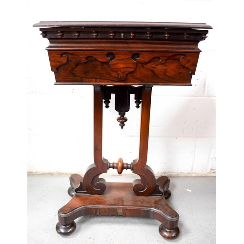 493 - A 19th century rosewood teapoy, the lid opens to reveal a fitted interior of three lined compartment... 