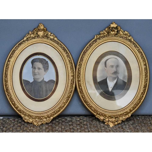 53 - A pair of late Victorian oval watercolour portraits of a lady and gentleman, in the studio style, ea... 