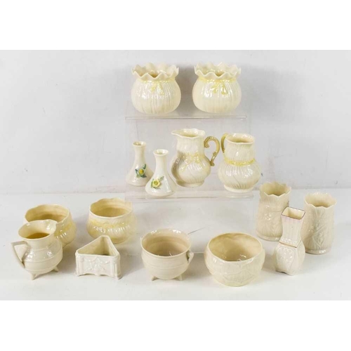 87 - A group of Belleek porcelain, including a cauldron jug with angular handle and three feet, and simil... 